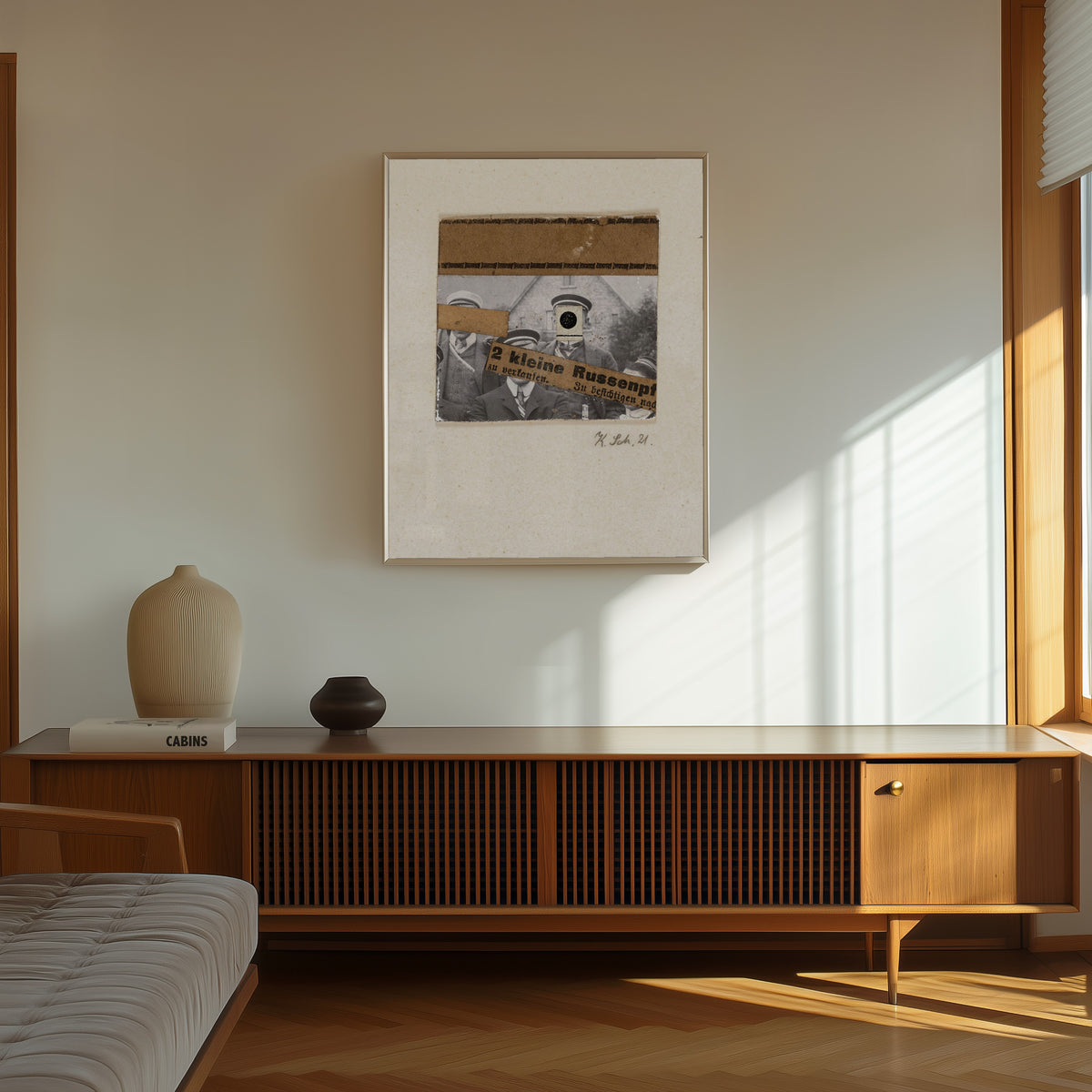Framed art print of Ohne titel (2 kleine Russenpf) by Kurt Schwitters, in a thin light frame on a sunlit wall above a wooden sideboard