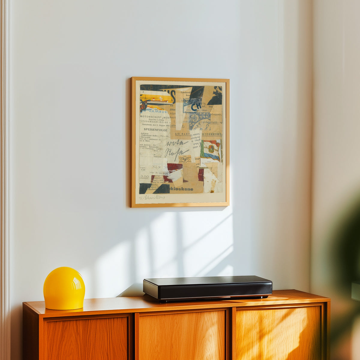 Framed art print of Ohne Titel (Rote Rose) by Kurt Schwitters, in a light wood frame on a white wall above an orange sideboard
