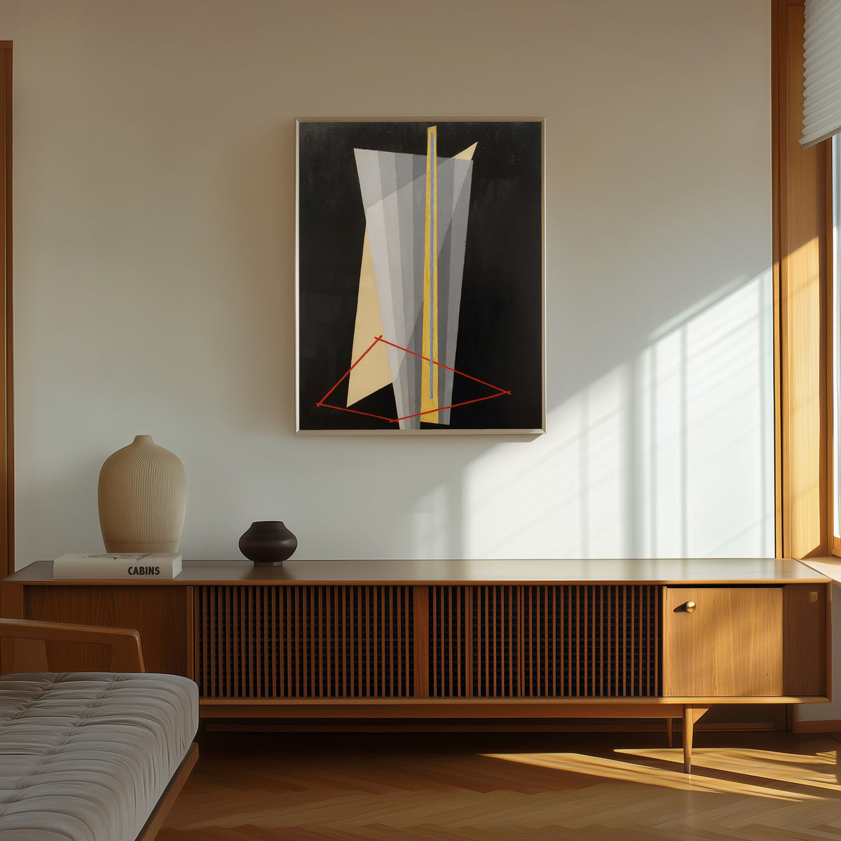 Framed art print of Construction (1922) by László Moholy-Nagy, in a thin light frame on a sunlit wall above a wooden sideboard