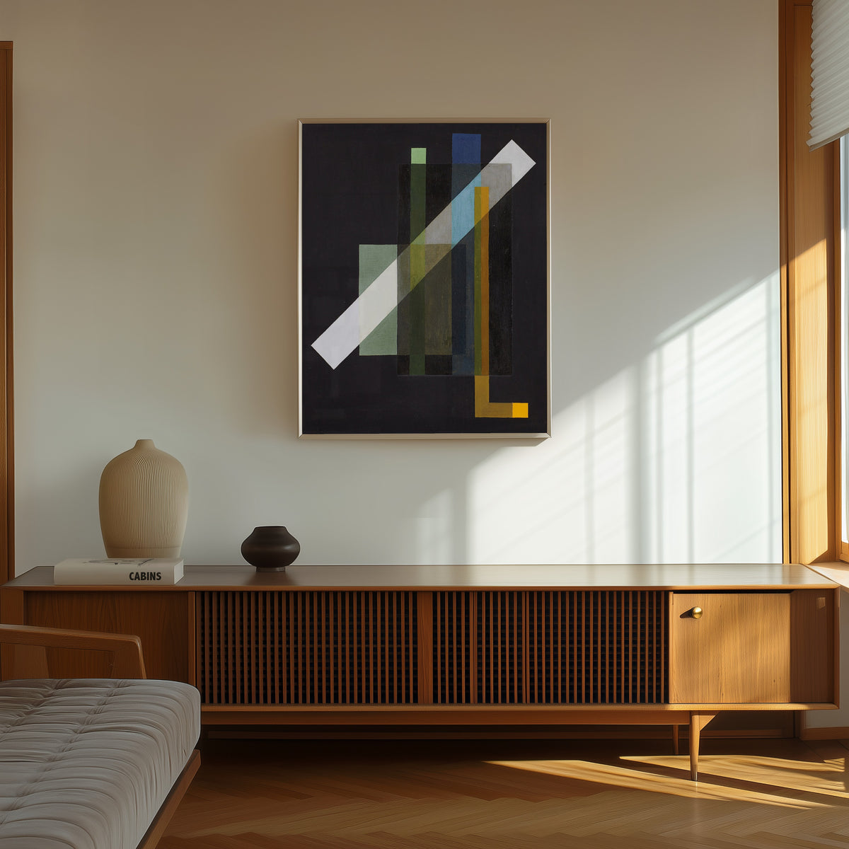 Framed art print of Construction (1924) by László Moholy-Nagy, in a thin light frame on a sunlit wall above a wooden sideboard