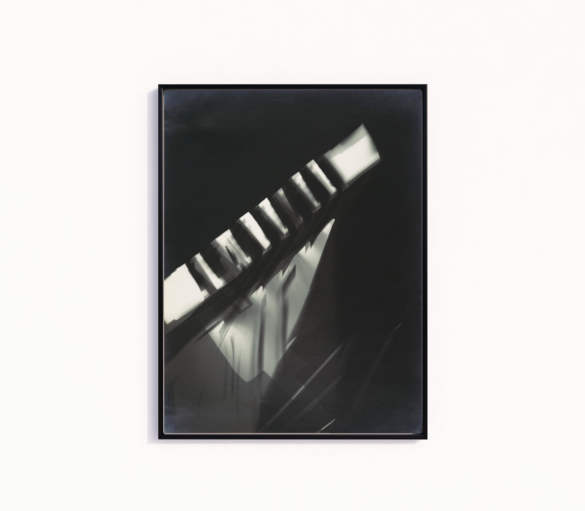 Framed art print of Fotogramm (1925–1928) by László Moholy-Nagy, in a slim black frame on a plain white wall