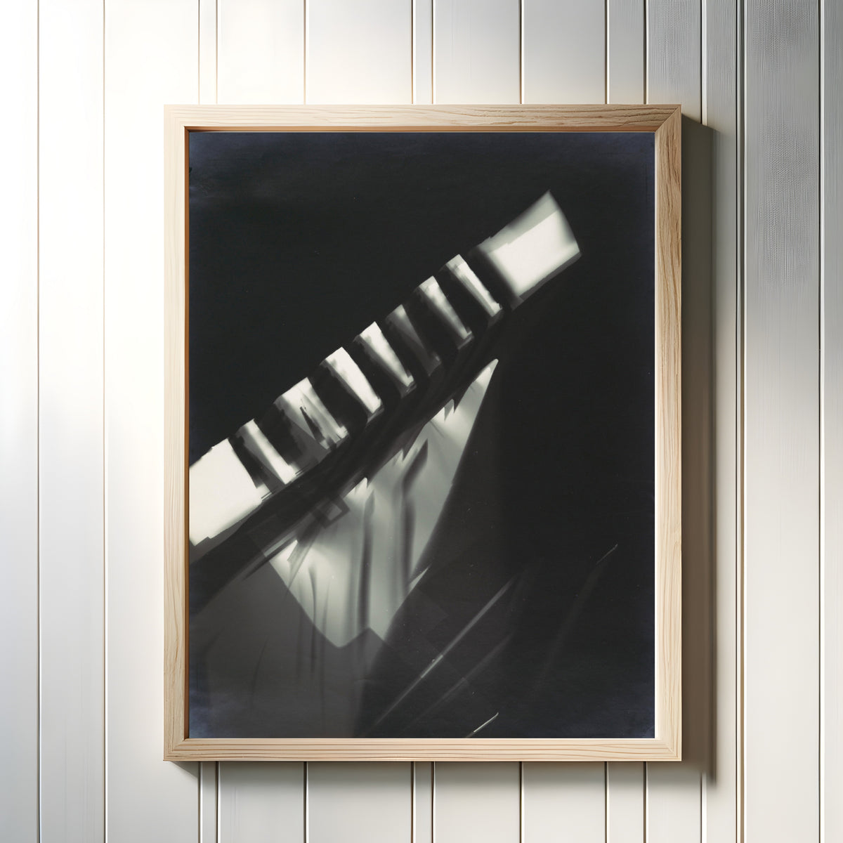 Framed art print of Fotogramm (1925–1928) by László Moholy-Nagy, in a light wood frame on a white panelled wall