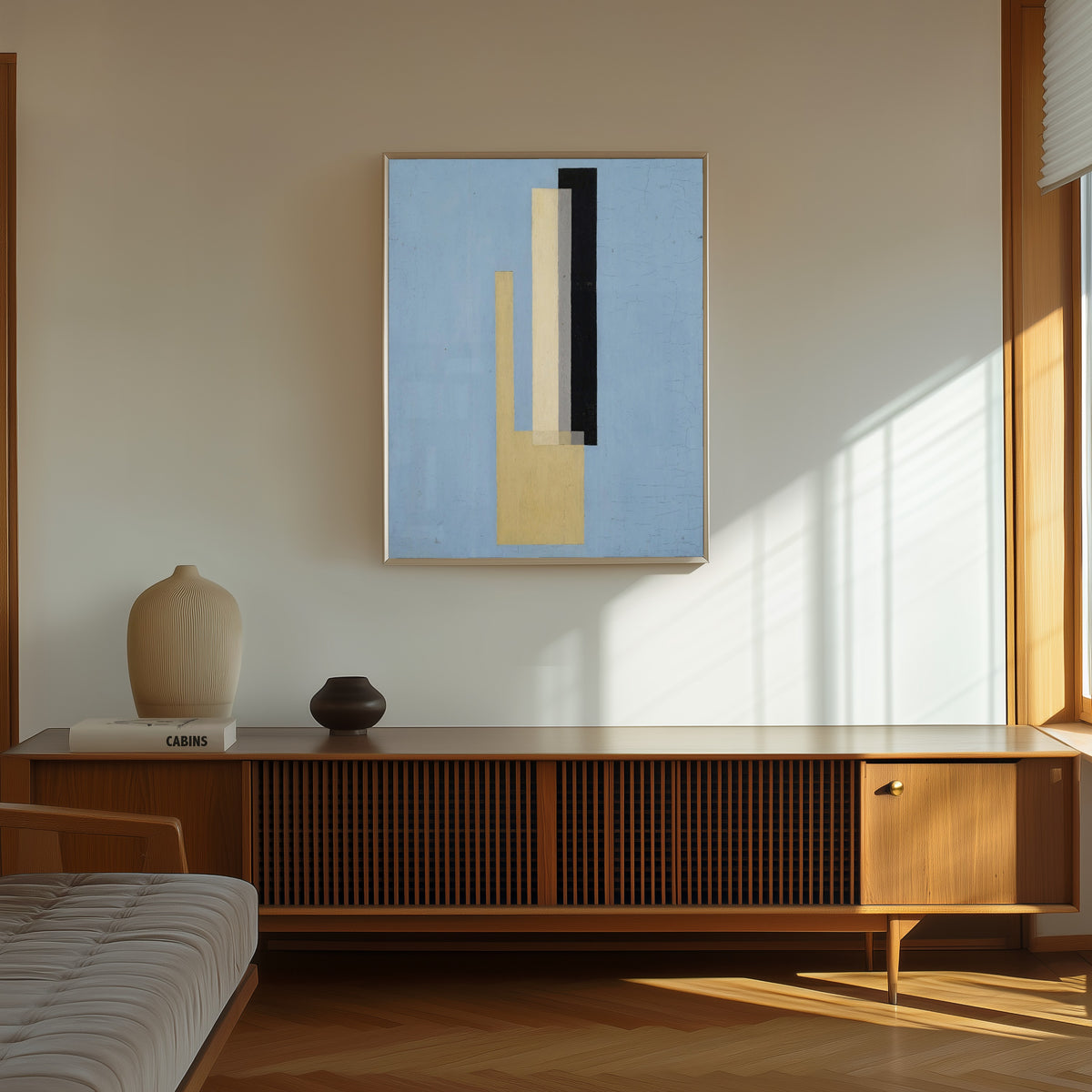 Framed art print of Konstruktion by László Moholy-Nagy, in a thin light frame on a sunlit wall above a wooden sideboard