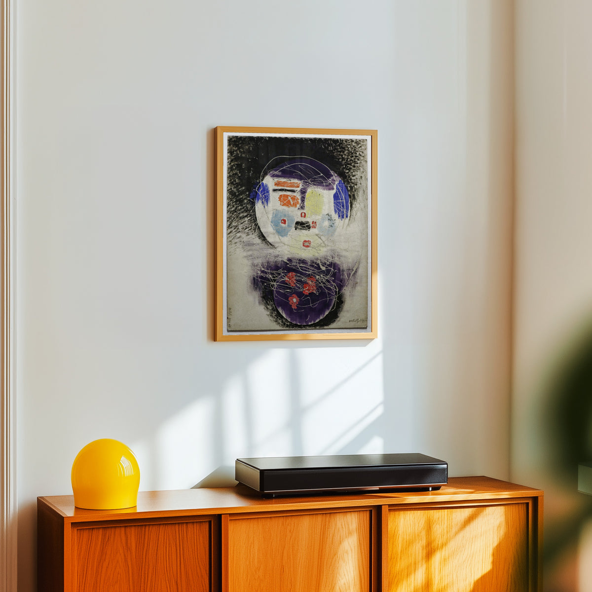 Framed art print of Space Construction by László Moholy-Nagy, in a light wood frame on a white wall above an orange sideboard