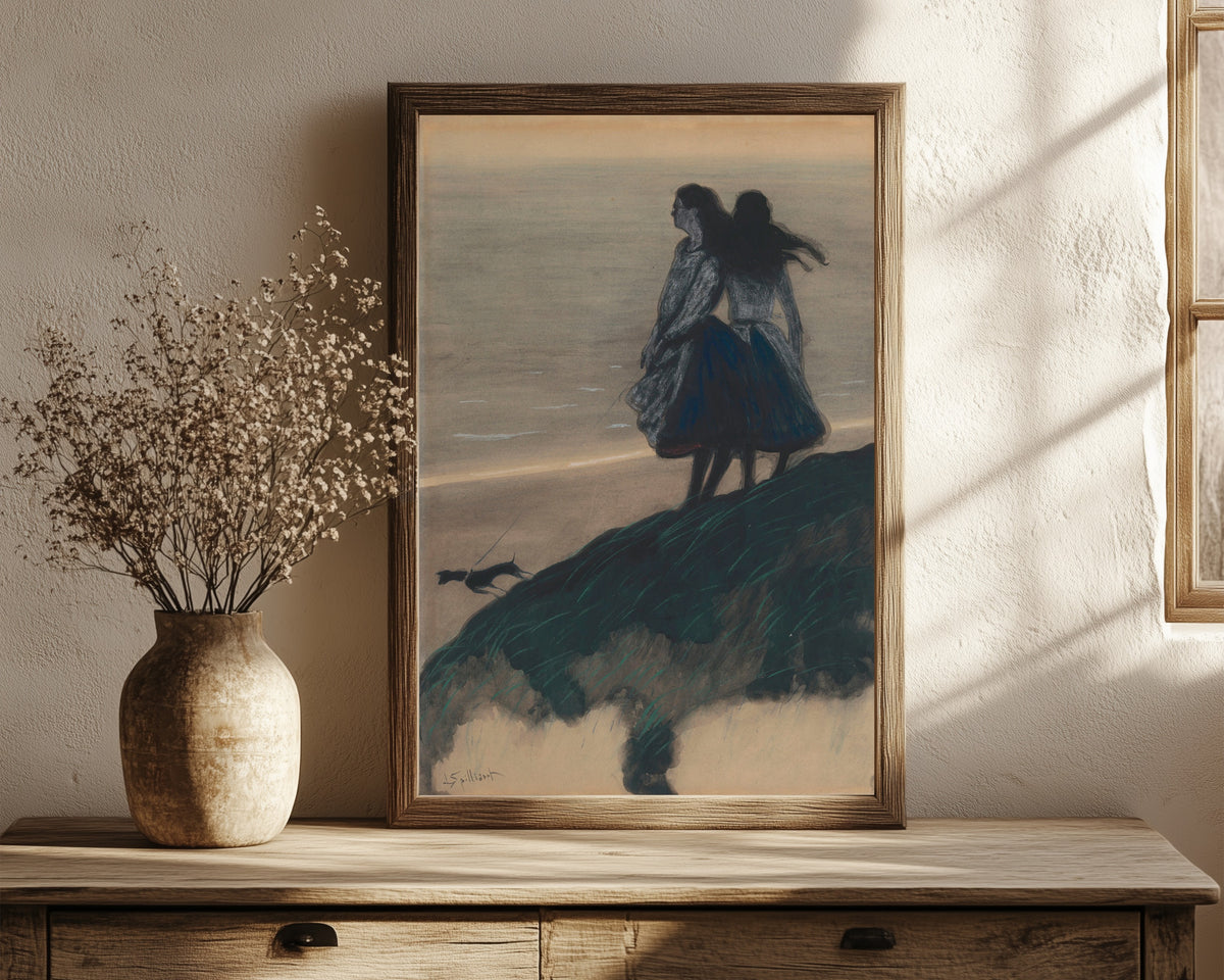 Framed art print of Girls on a Dune by Léon Spilliaert, in a dark wood frame leaning on a rustic console beside dried flowers