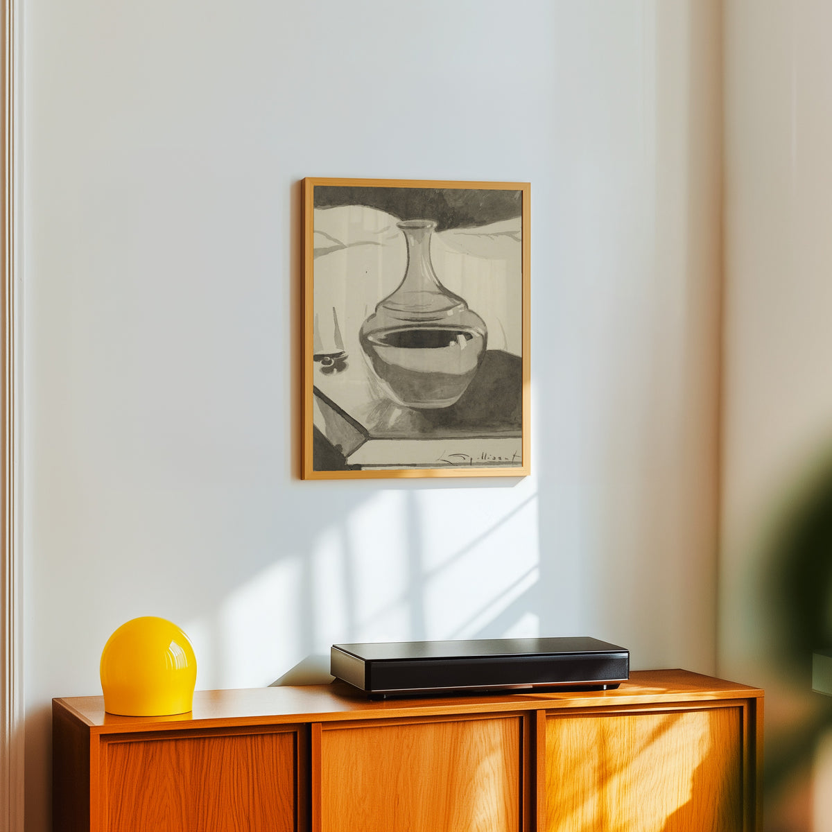 Framed art print of Karaf op nachttafel by Léon Spilliaert, in a light wood frame on a white wall above an orange sideboard