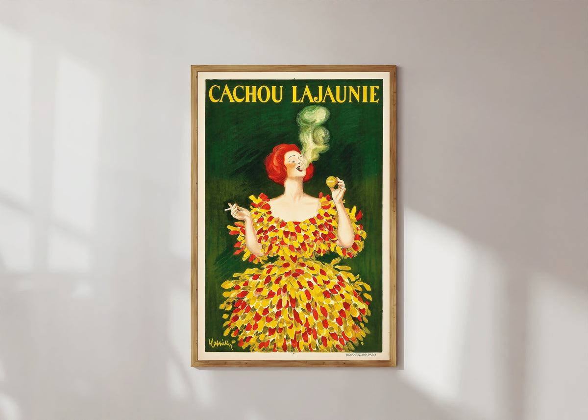 Framed art print of Cachou Lajaunie by Leonetto Cappiello, in a light wood frame on a sunlit white wall