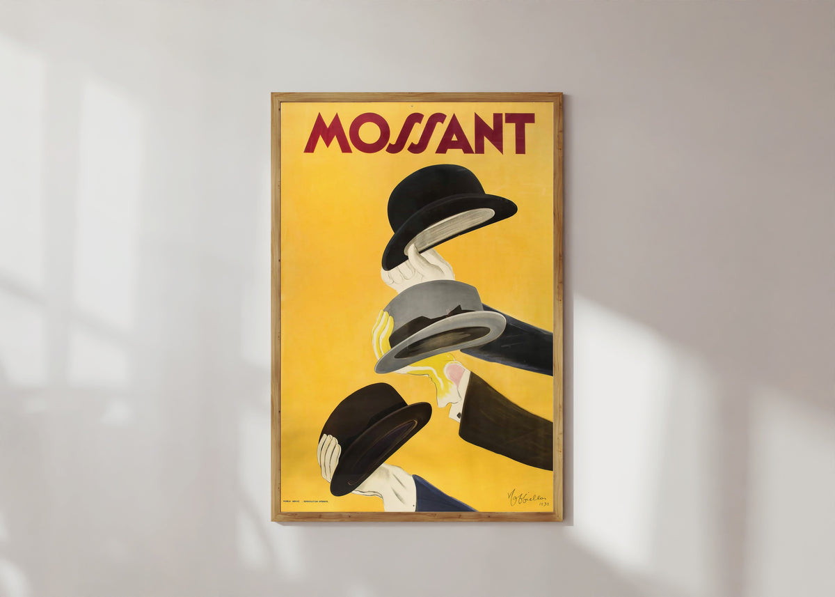 Framed art print of Mossant by Leonetto Cappiello, in a light wood frame on a sunlit white wall