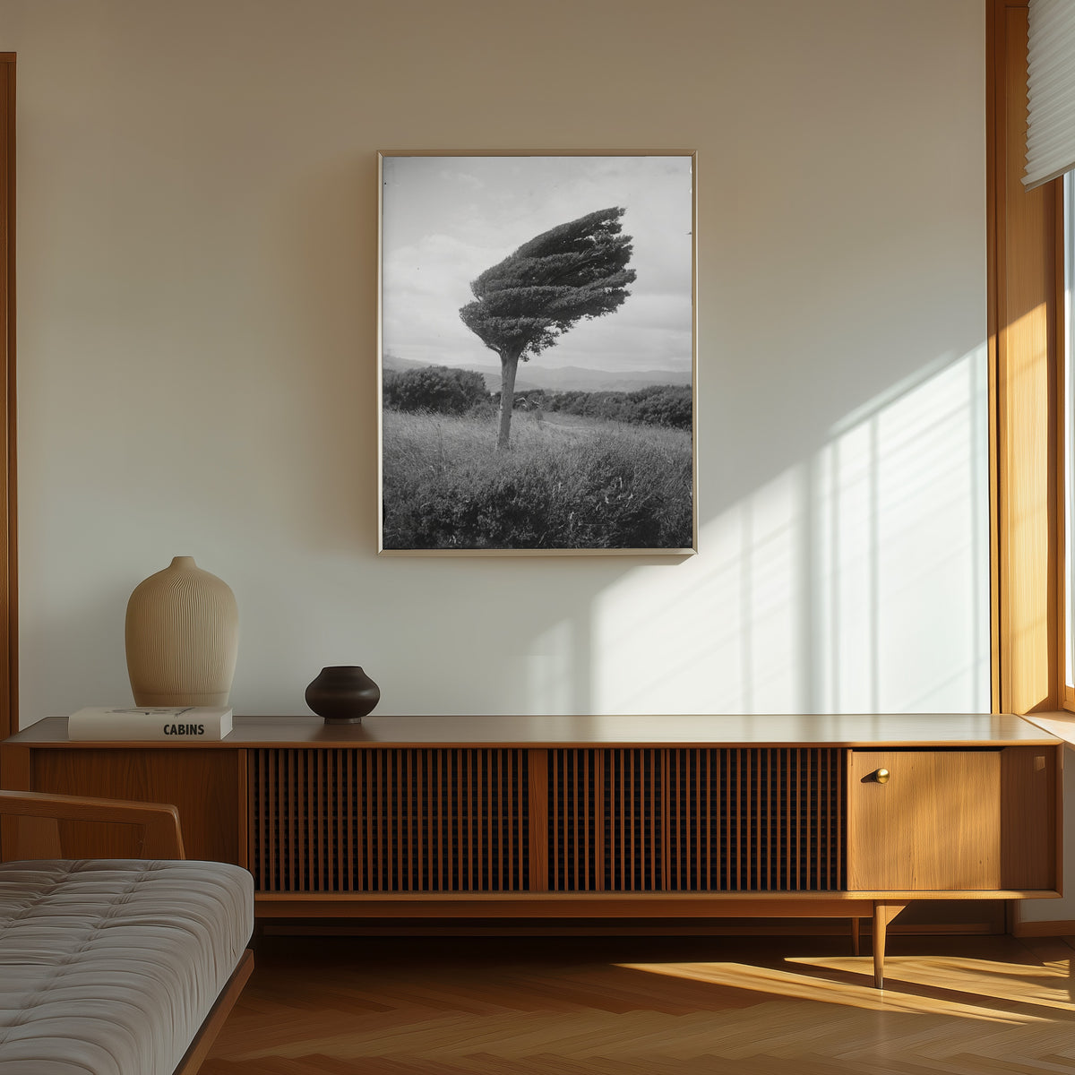 Framed art print of Small Totara Tree by Leslie Adkin, in a thin light frame on a sunlit wall above a wooden sideboard