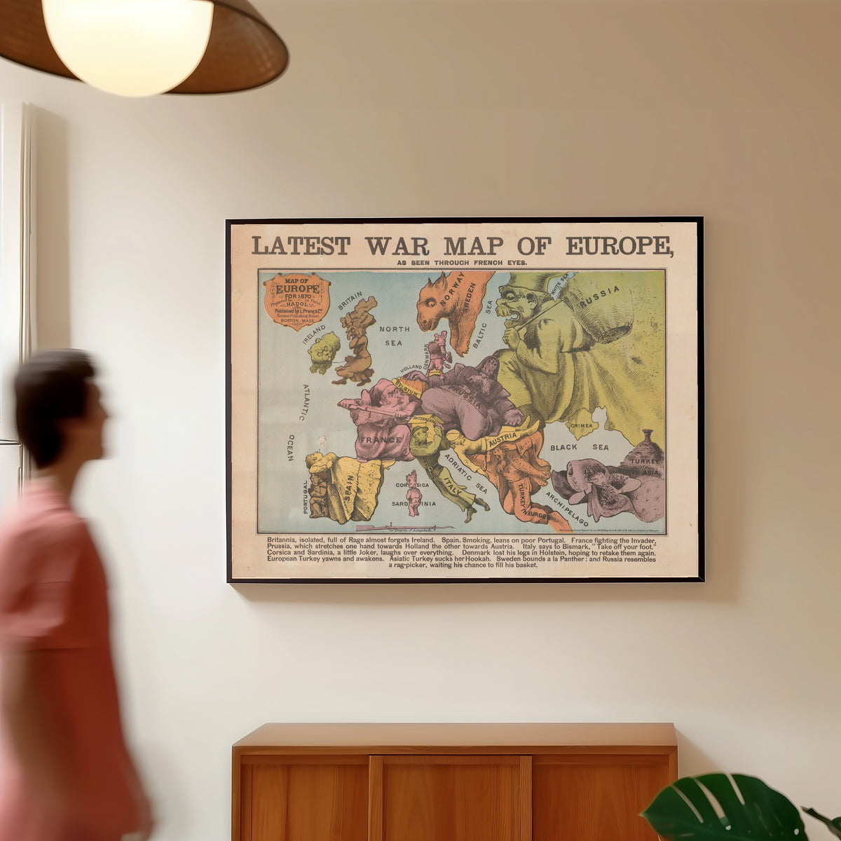 Framed art print of Latest War Map of Europe, as Seen Through French Eyes by Louis Prang & Co., in a slim black frame on a warm wall in a sunlit room
