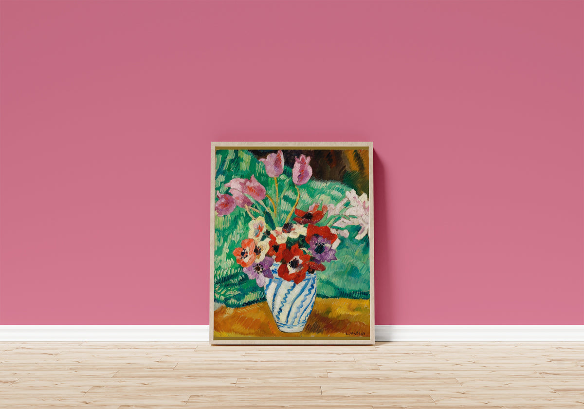 Framed art print of Tulips and Anemones by Louis Valtat, in a light wood frame leaning on a pink wall above a wooden floor