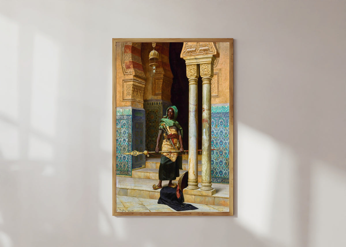 Framed art print of The Nubian Guard by Ludwig Deutsch, in a light wood frame on a sunlit white wall
