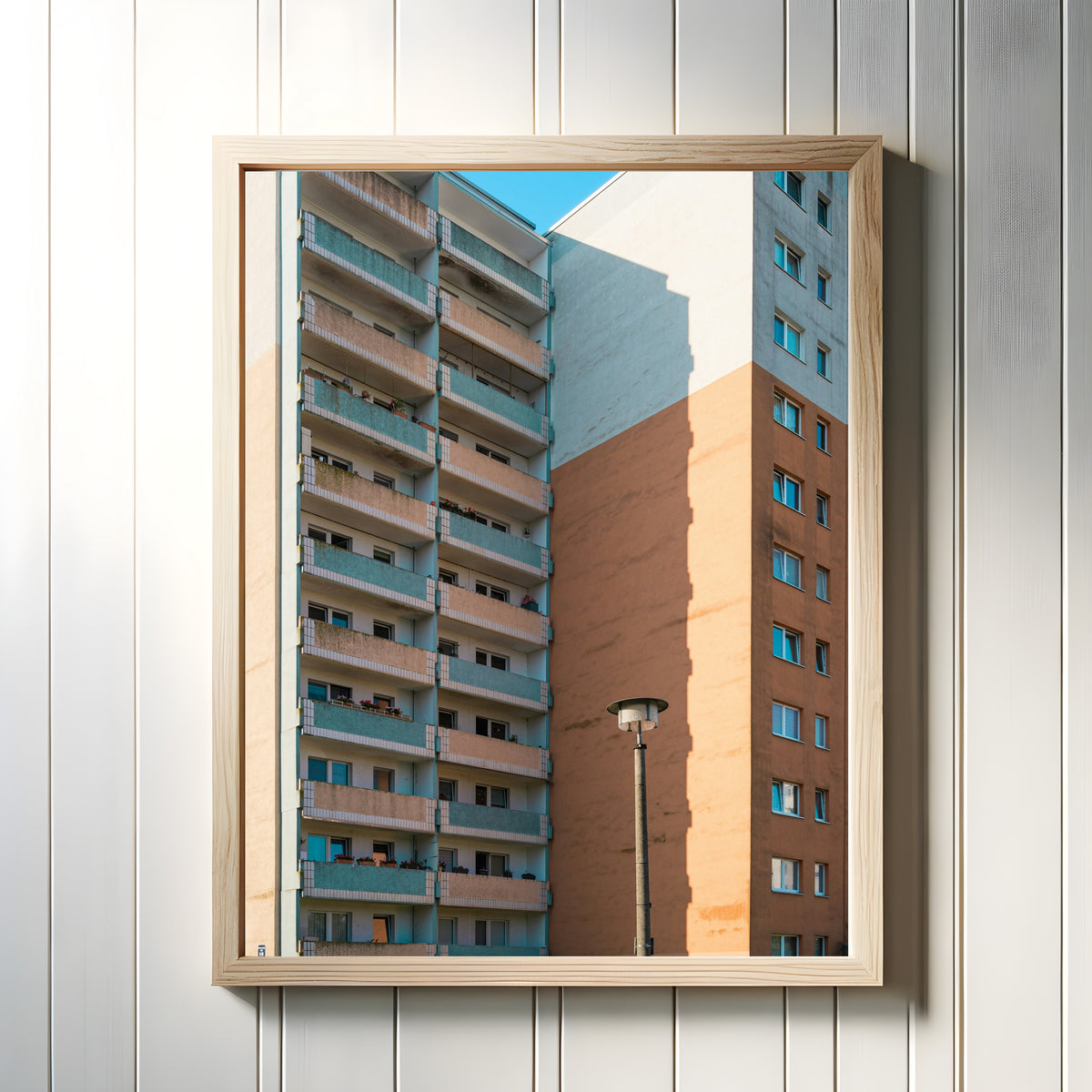 Framed art print of Light and Shadow V by Marcus Lenk, in a light wood frame on a white panelled wall