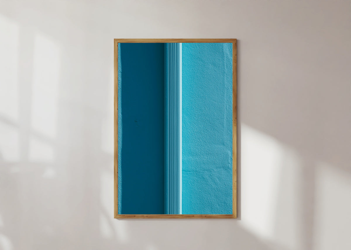 Framed art print of Light and Shadow VII by Marcus Lenk, in a light wood frame on a sunlit white wall
