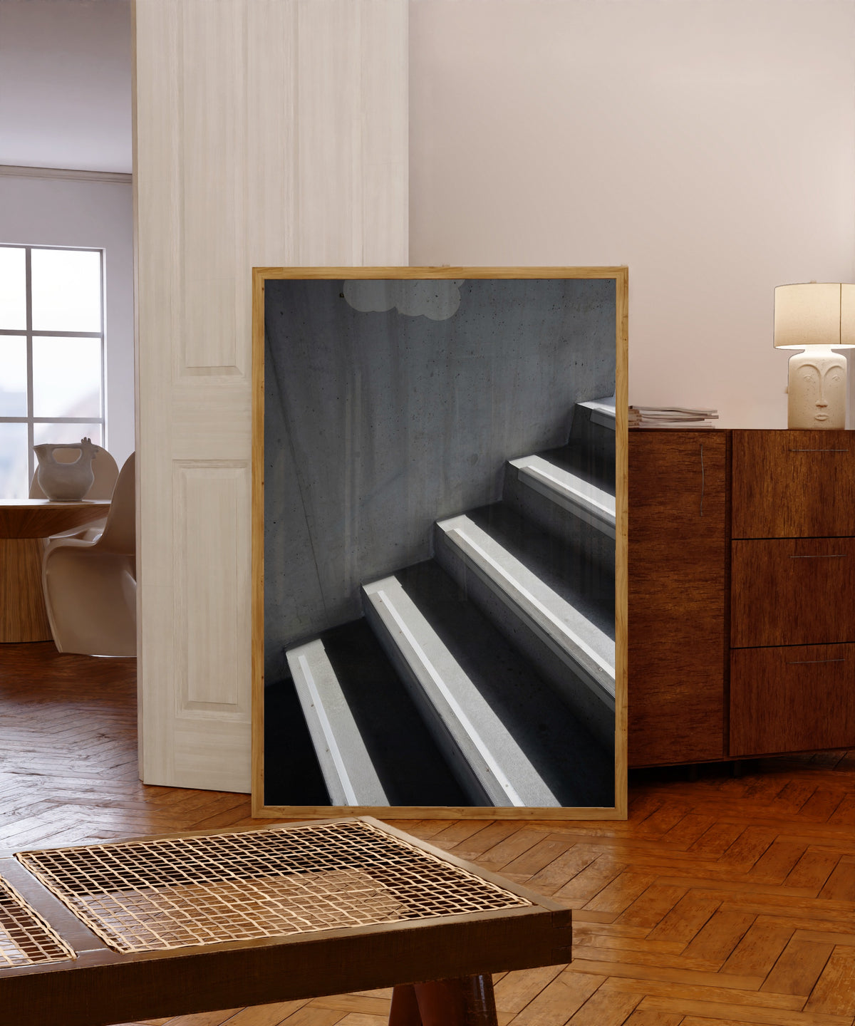 Framed art print of Light and Shadow VIII by Marcus Lenk, in a light wood frame leaning in a warm room with a parquet floor