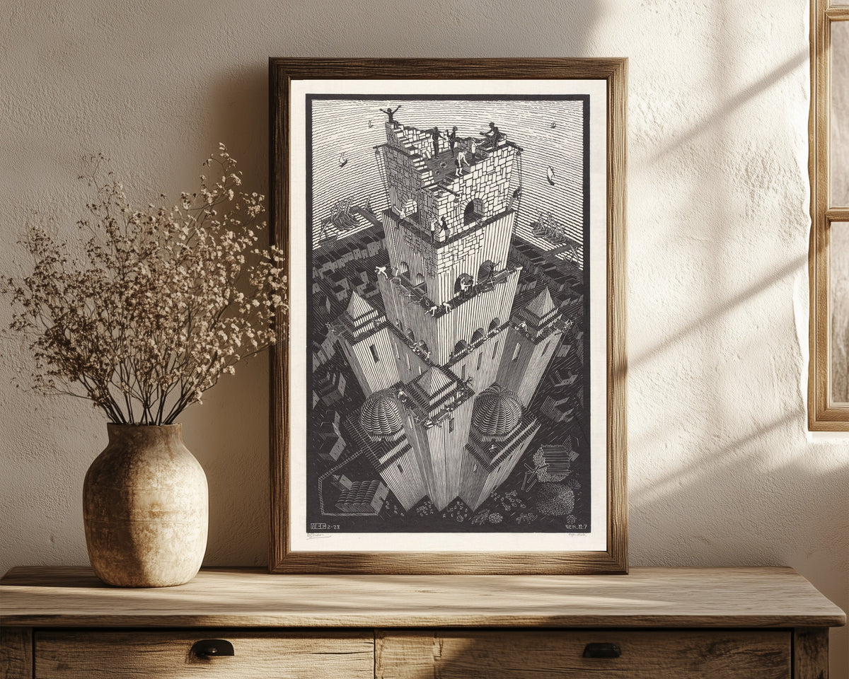 Framed art print of The Tower of Babel by M.C. Escher, in a dark wood frame leaning on a rustic console beside dried flowers