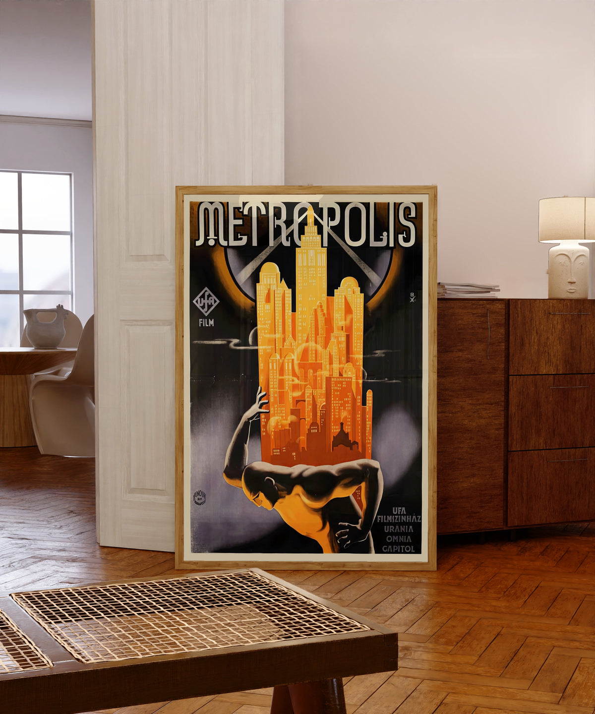 Framed art print of Metropolis Movie Poster by Heinz Schulz-Neudamm, in a light wood frame leaning in a warm room with a parquet floor