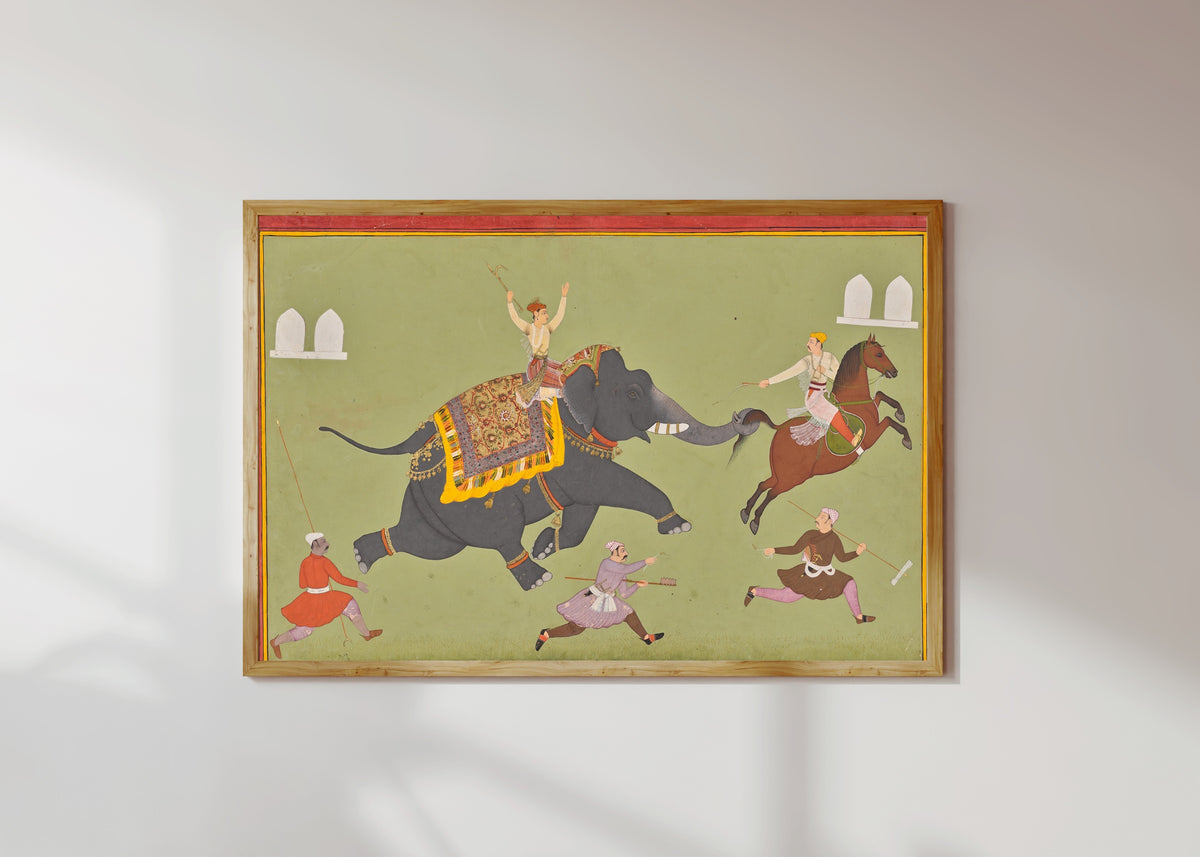 Framed art print of The Elephant of Maharana Jai Singh of Mewar Catches a Horse by the Tail by Mewar school, in a light wood frame on a sunlit white wall