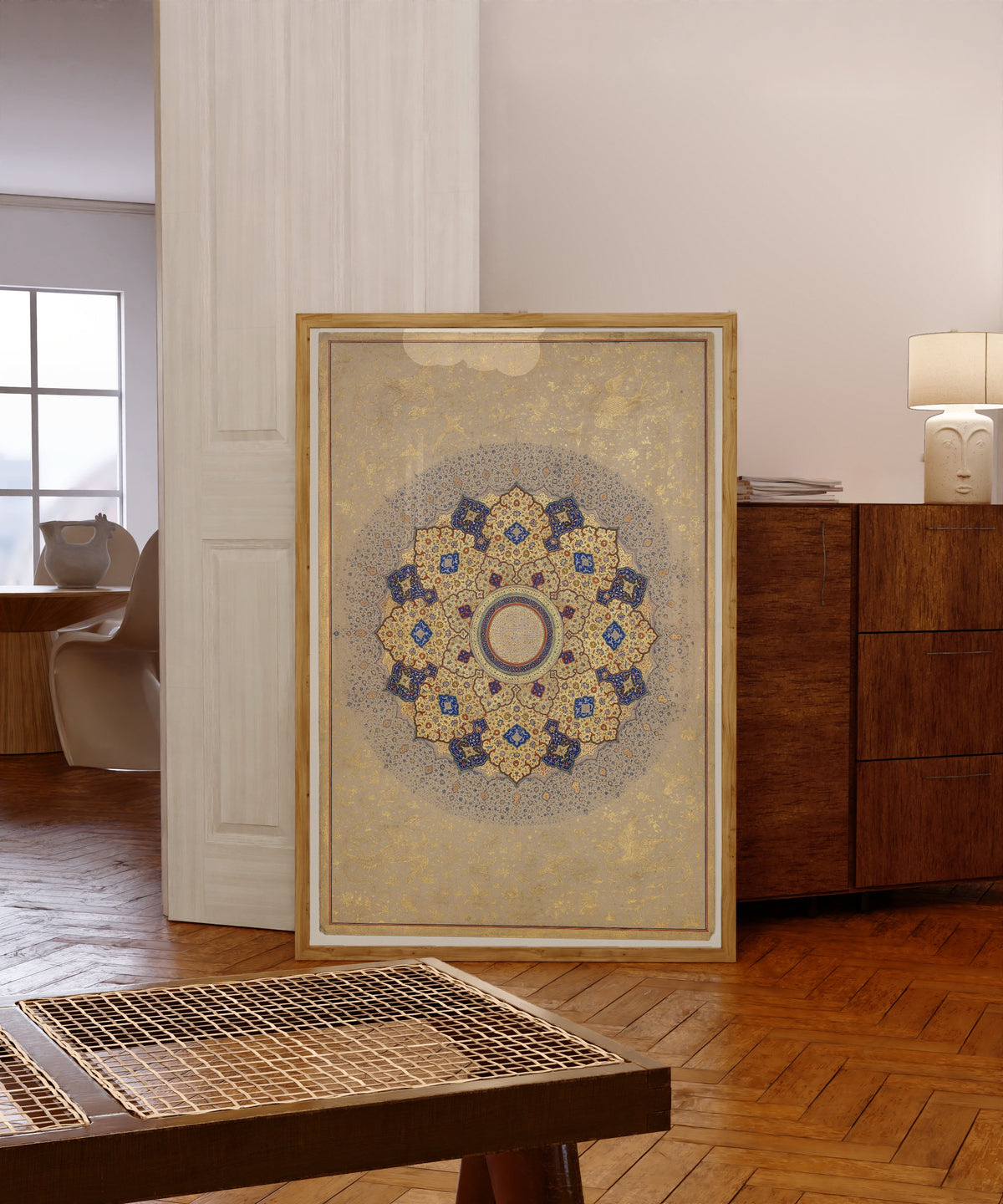 Framed art print of Rosette Bearing the Names and Titles of Shah Jahan, Folio from the Shah…, in a light wood frame leaning in a warm room with a parquet floor