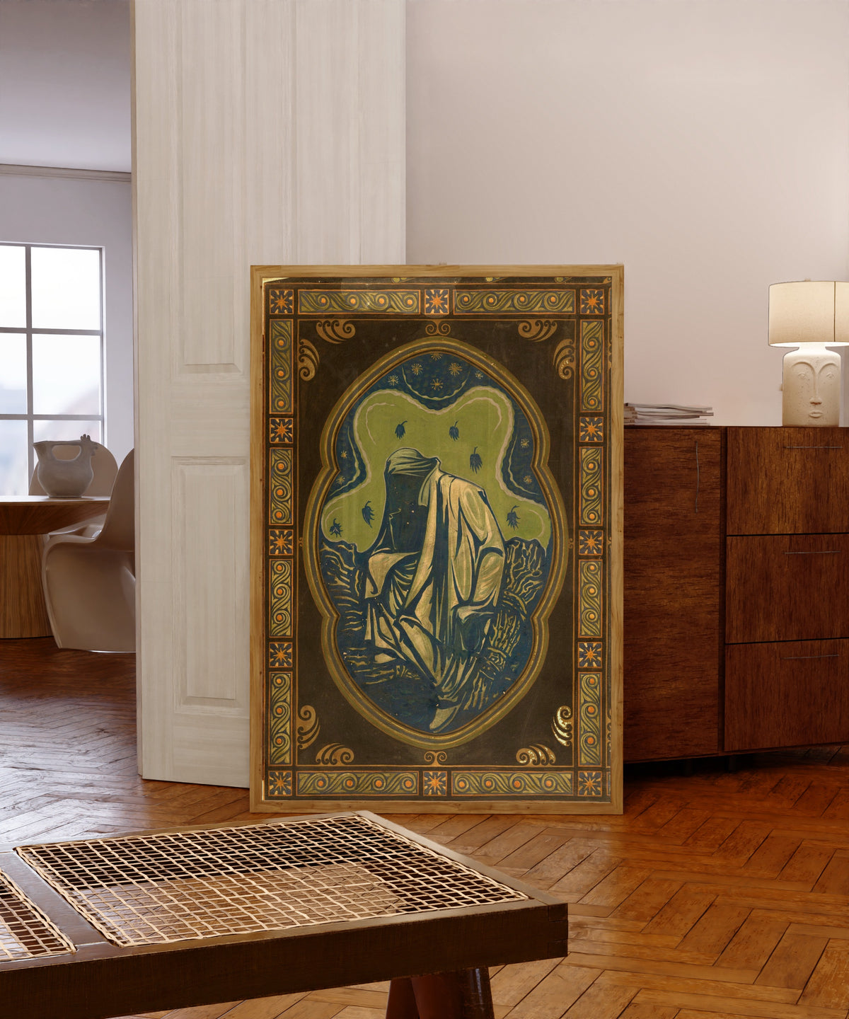Framed art print of Night by Richard Roland Holst, in a light wood frame leaning in a warm room with a parquet floor