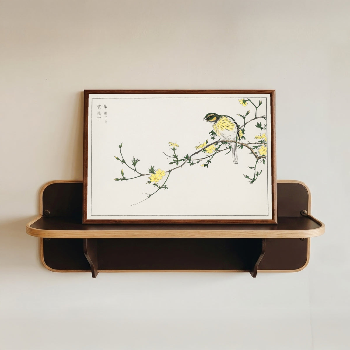 Framed art print of Black-faced Bunting and Winter Jasmine by Numata Kashū, in a dark wood frame resting on a wall shelf