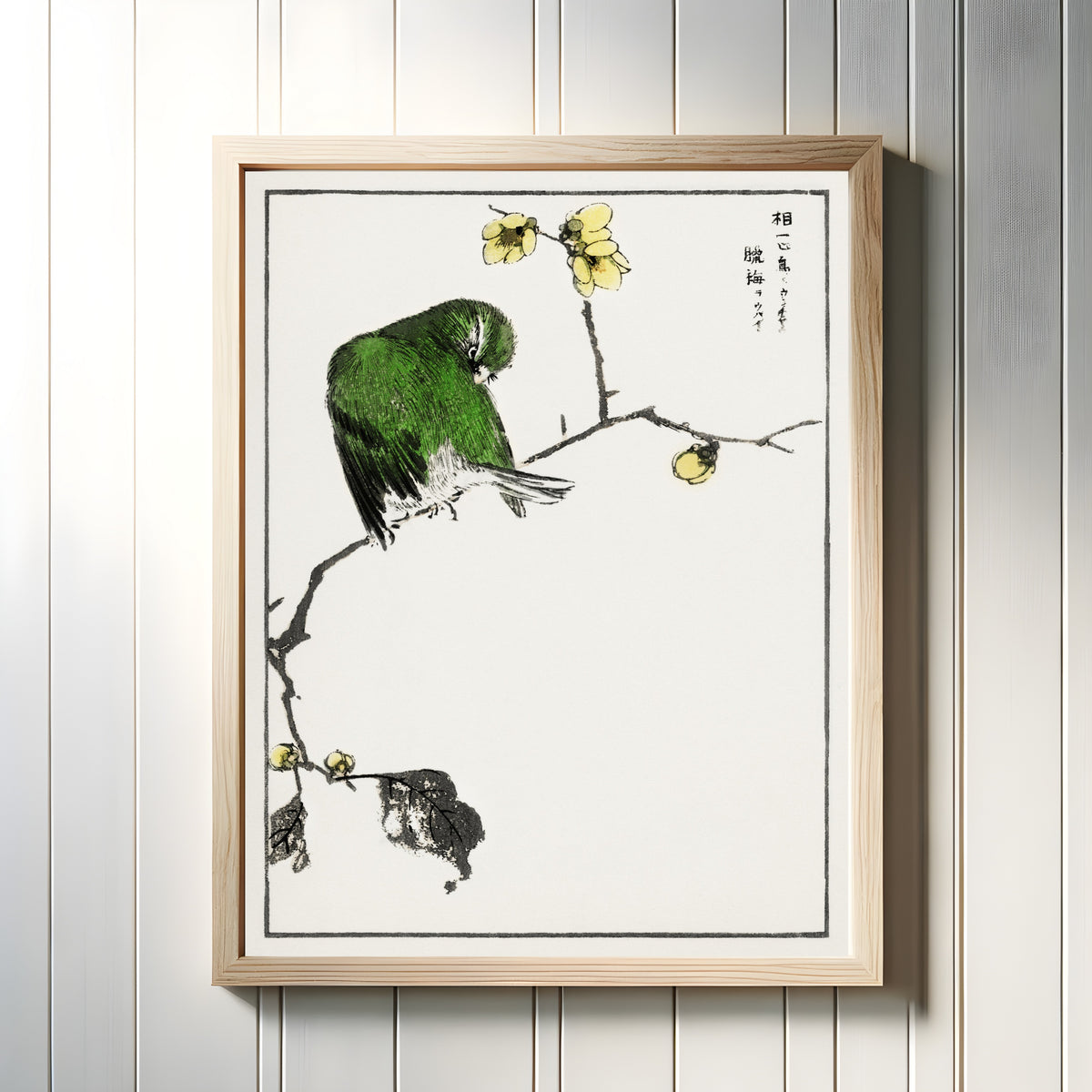 Framed art print of Red-billed Leiothrix and Wintersweet by Numata Kashū, in a light wood frame on a white panelled wall