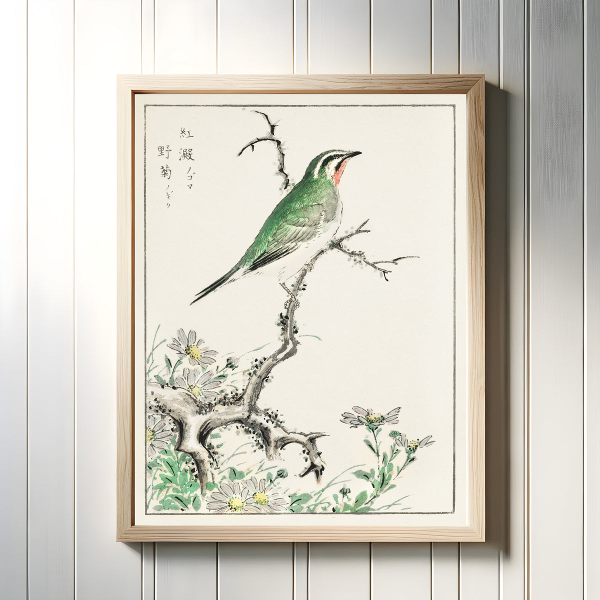 Framed art print of Ruby Throat and Wild Chrysanthemum by Numata Kashū, in a light wood frame on a white panelled wall