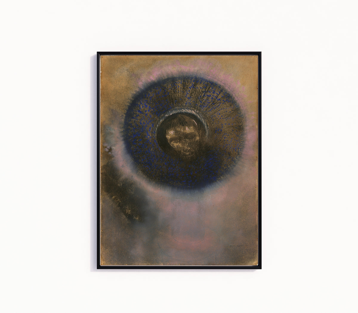 Framed art print of Head Within an Aureole (1895) by Odilon Redon, in a slim black frame on a plain white wall