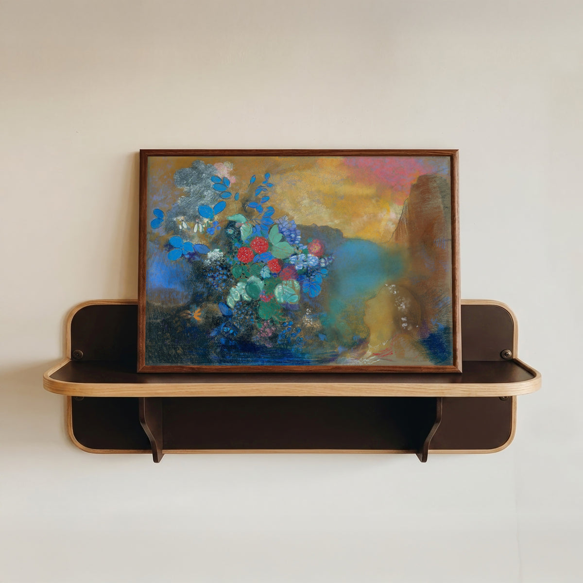 Framed art print of Ophelia Among the Flowers (c. 1905) by Odilon Redon, in a dark wood frame resting on a wall shelf