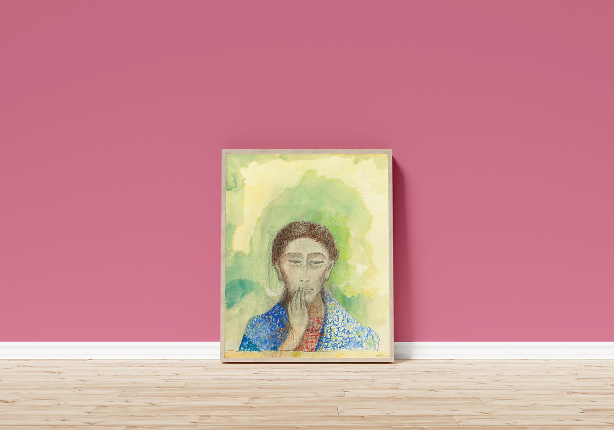Framed art print of Silence by Odilon Redon, in a light wood frame leaning on a pink wall above a wooden floor
