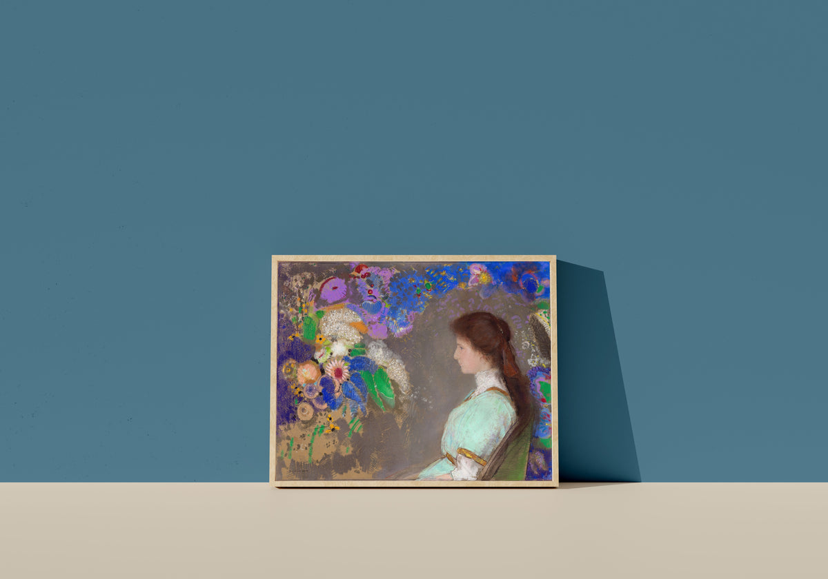 Framed art print of Violette Heymann by Odilon Redon, in a light wood frame leaning on a blue wall
