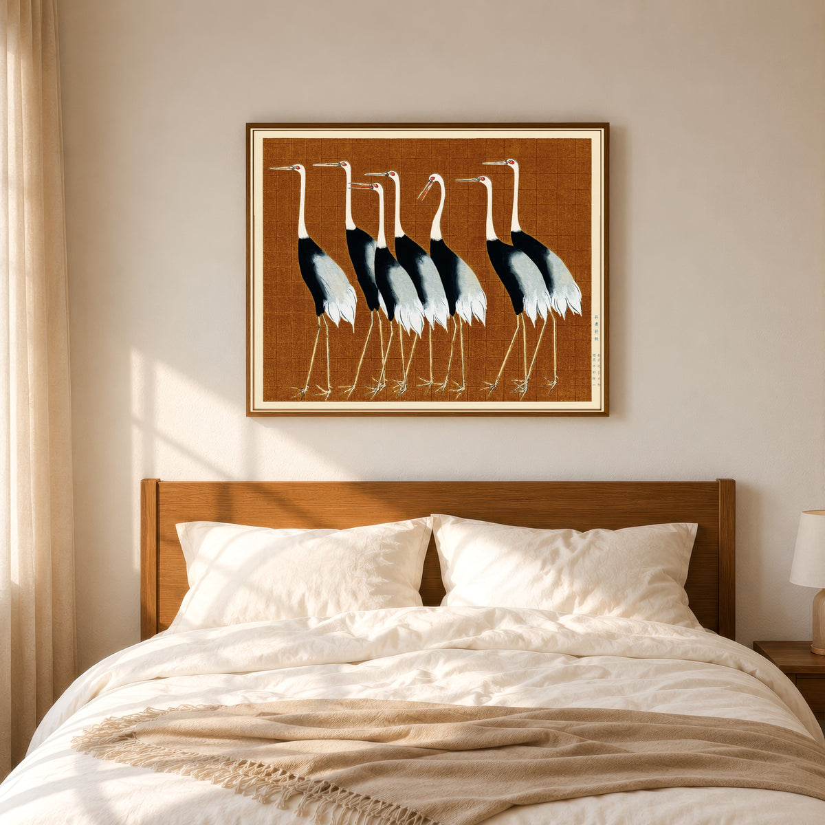 Framed art print of Cranes in Brown by Ogata Korin, in a slim wood frame above a bed in a sunlit bedroom