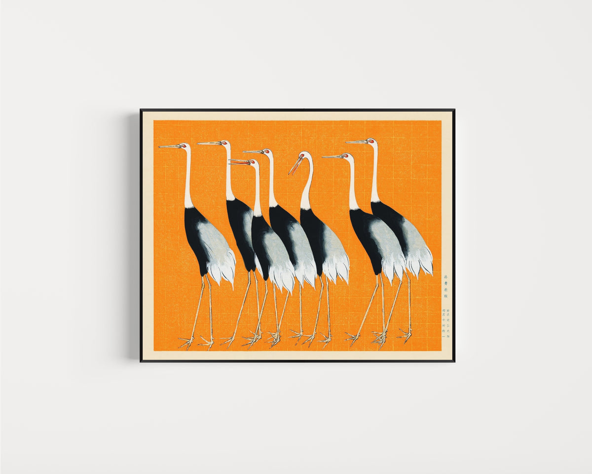 Framed art print of Cranes in Orange by Ogata Korin, in a slim black frame on a plain white wall