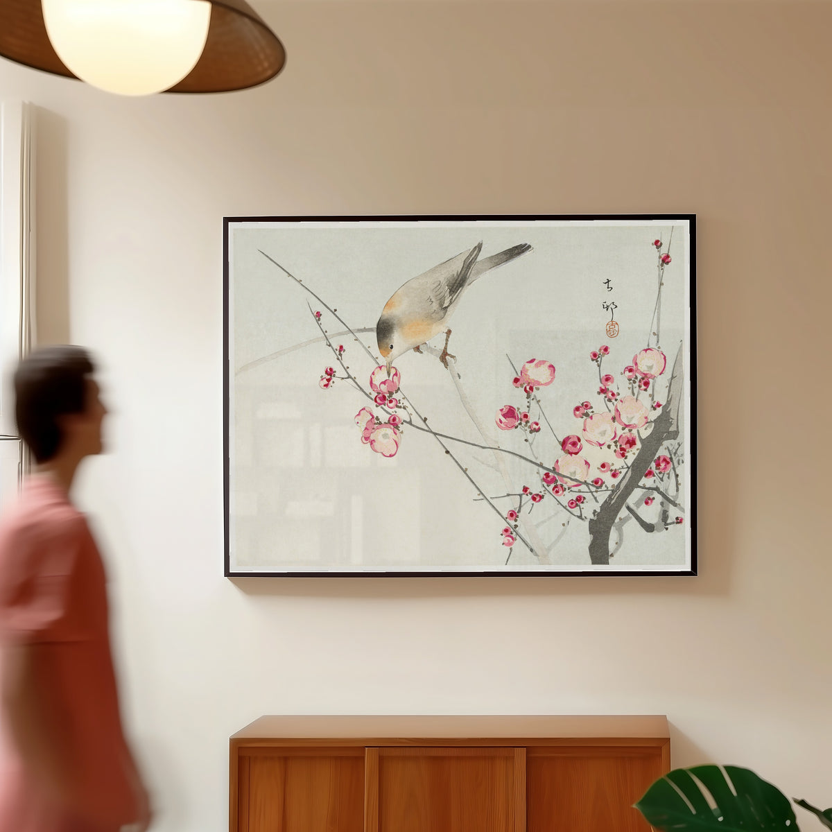 Framed art print of Songbird on Blossom Branch by Ohara Koson, in a slim black frame on a warm wall in a sunlit room