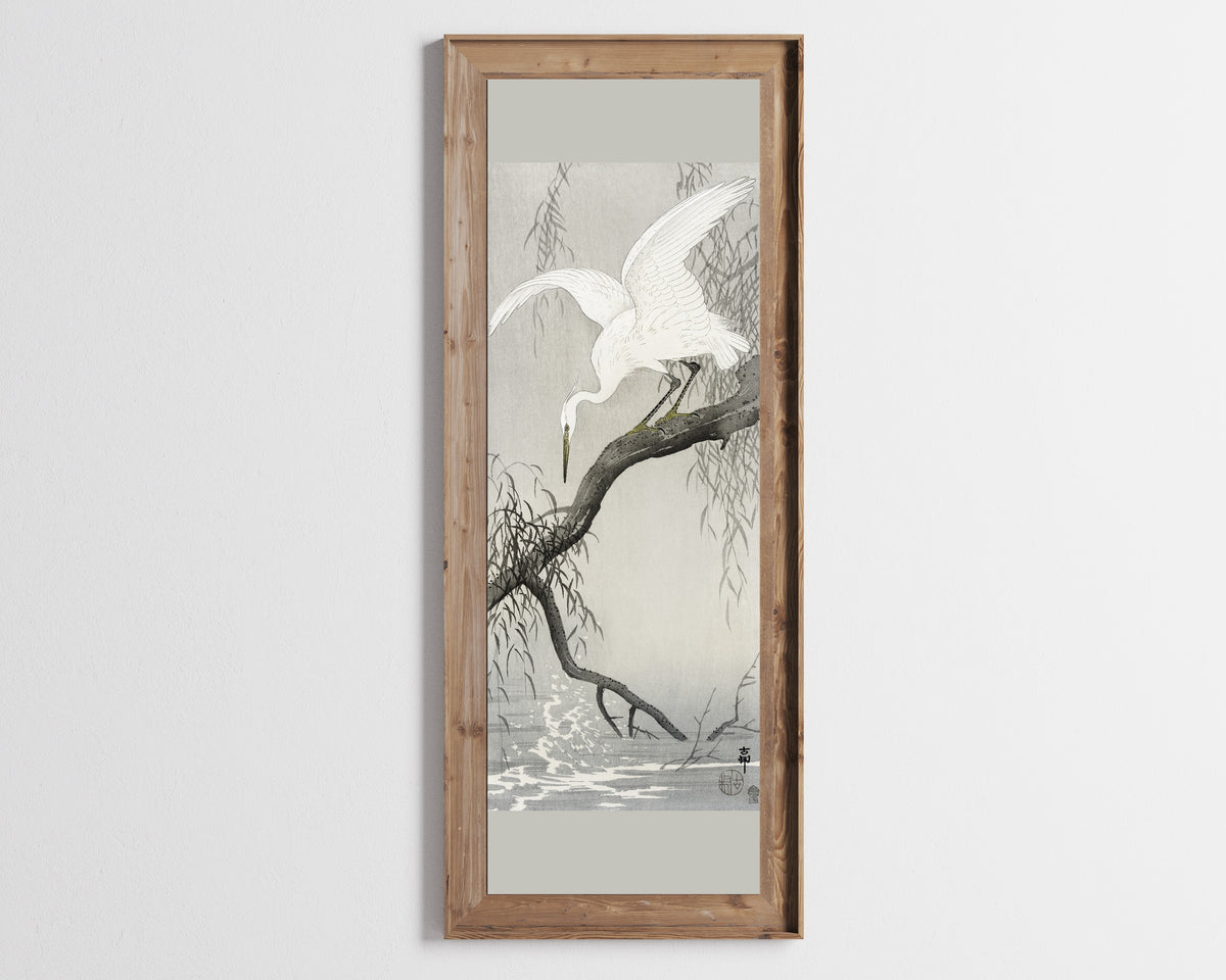 White Heron on Tree Branch by Ohara Koson — in a tall wooden frame on a pale wall