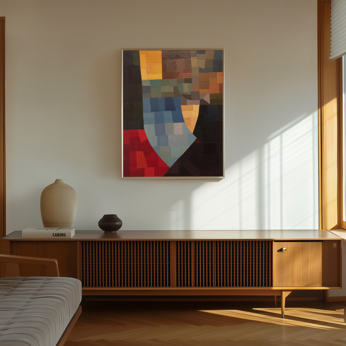 Framed art print of Komposition (1930) by Otto Freundlich, in a thin light frame on a sunlit wall above a wooden sideboard