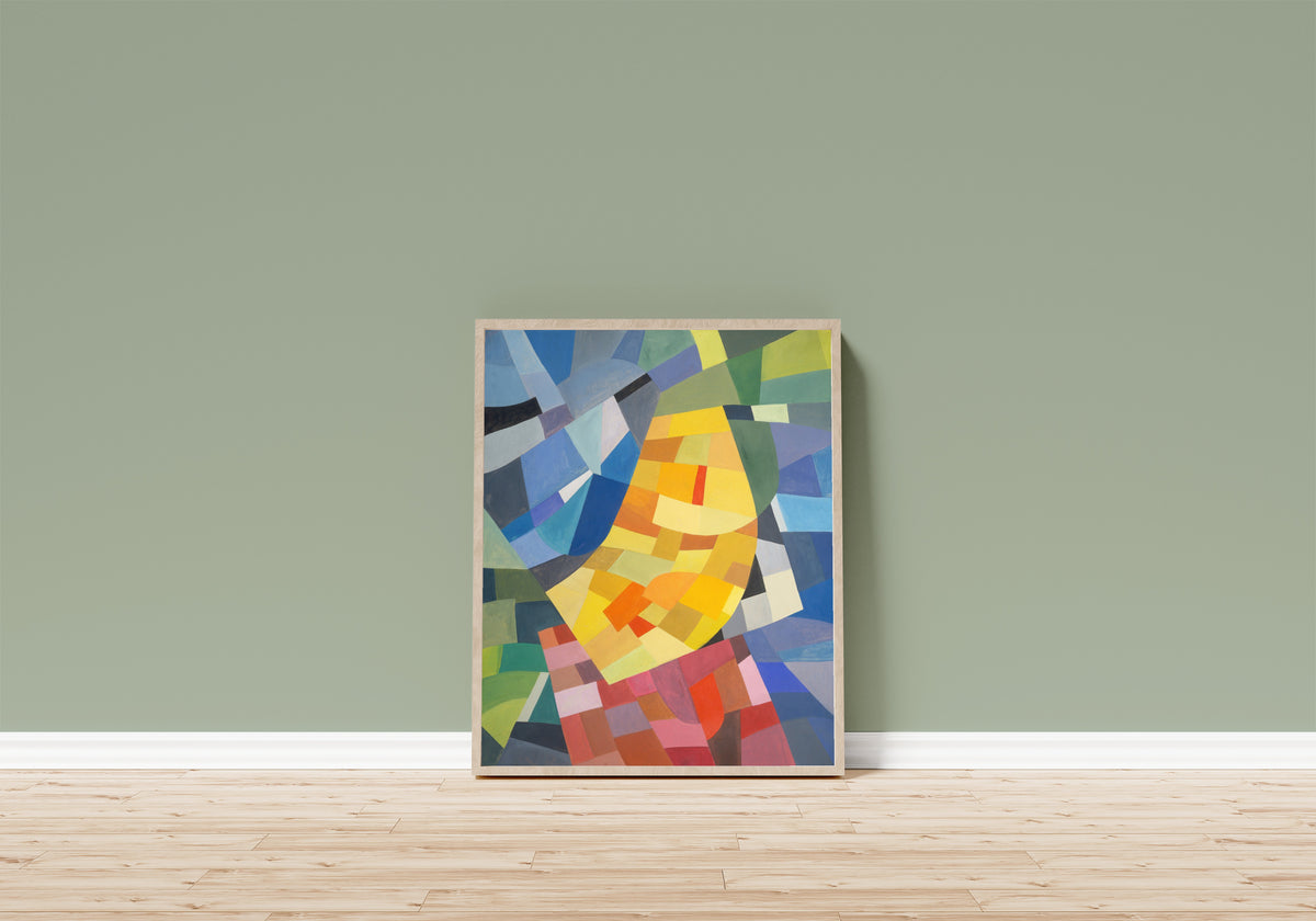 Framed art print of Komposition (1930) by Otto Freundlich, in a light wood frame leaning on a sage green wall above a wooden floor