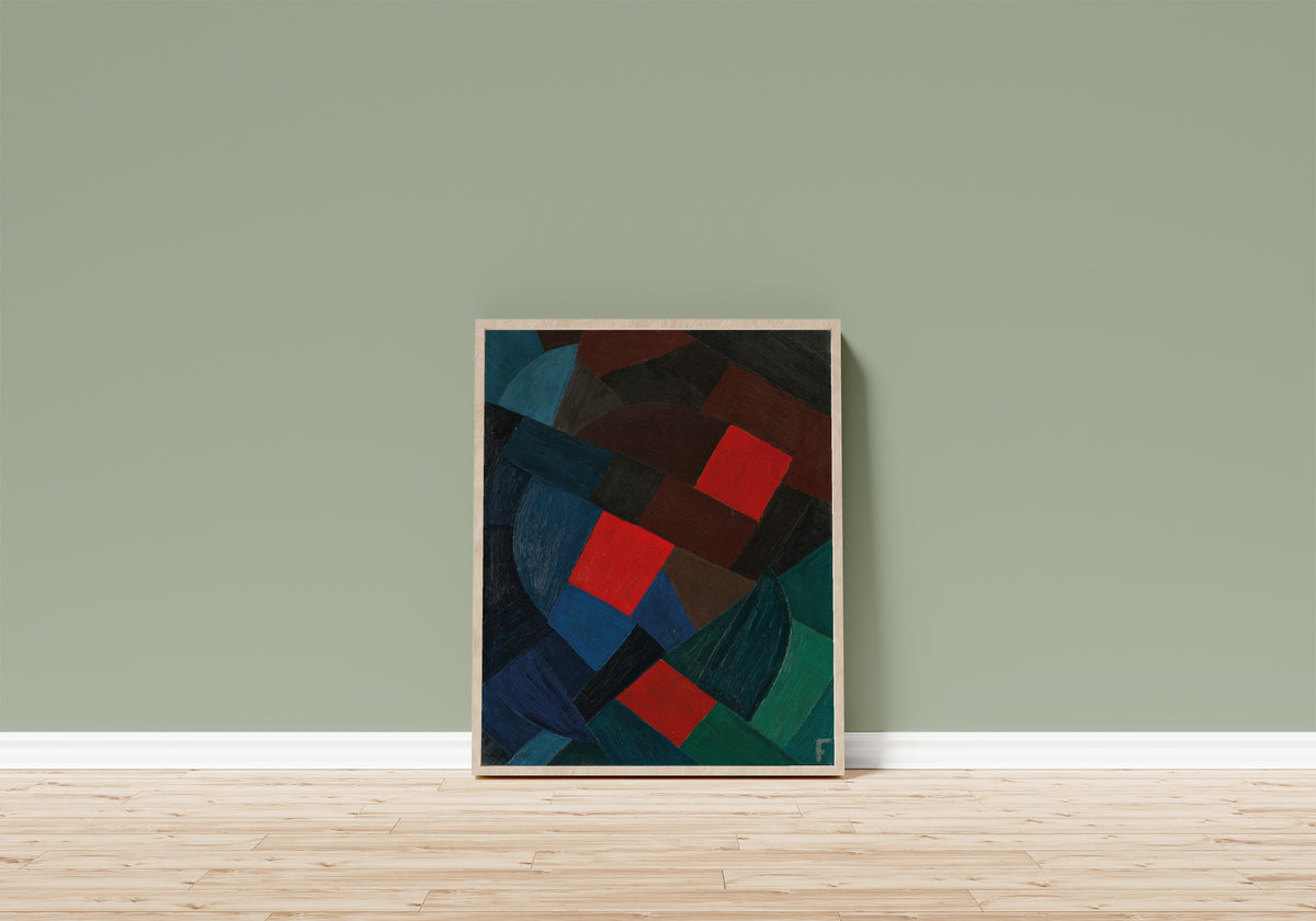 Framed art print of Komposition (1935–1936) by Otto Freundlich, in a light wood frame leaning on a sage green wall above a wooden floor