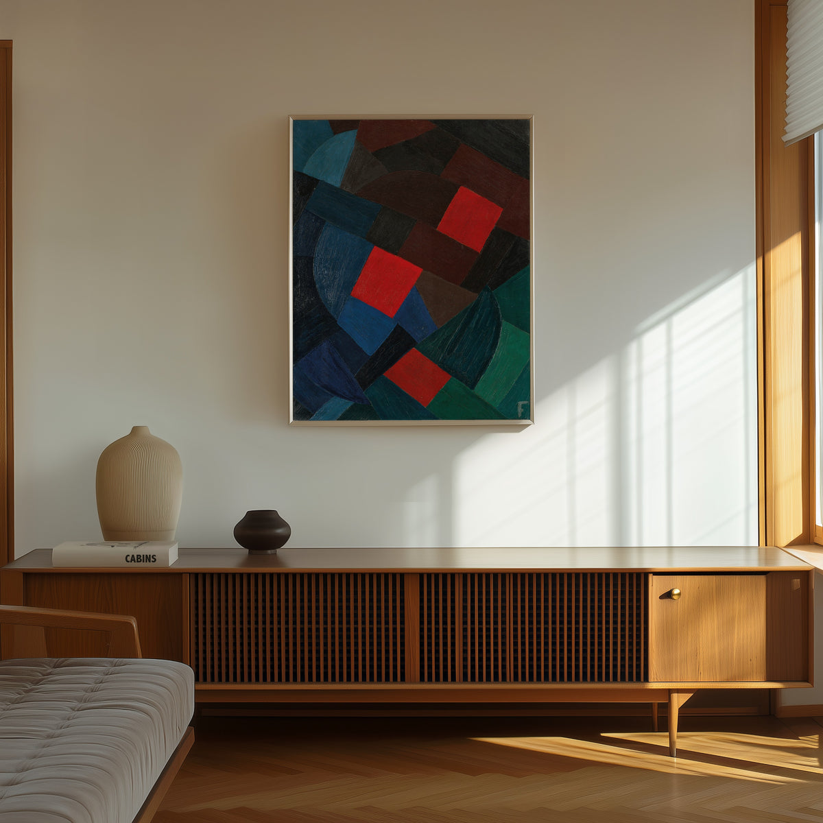 Framed art print of Komposition (1935–1936) by Otto Freundlich, in a thin light frame on a sunlit wall above a wooden sideboard