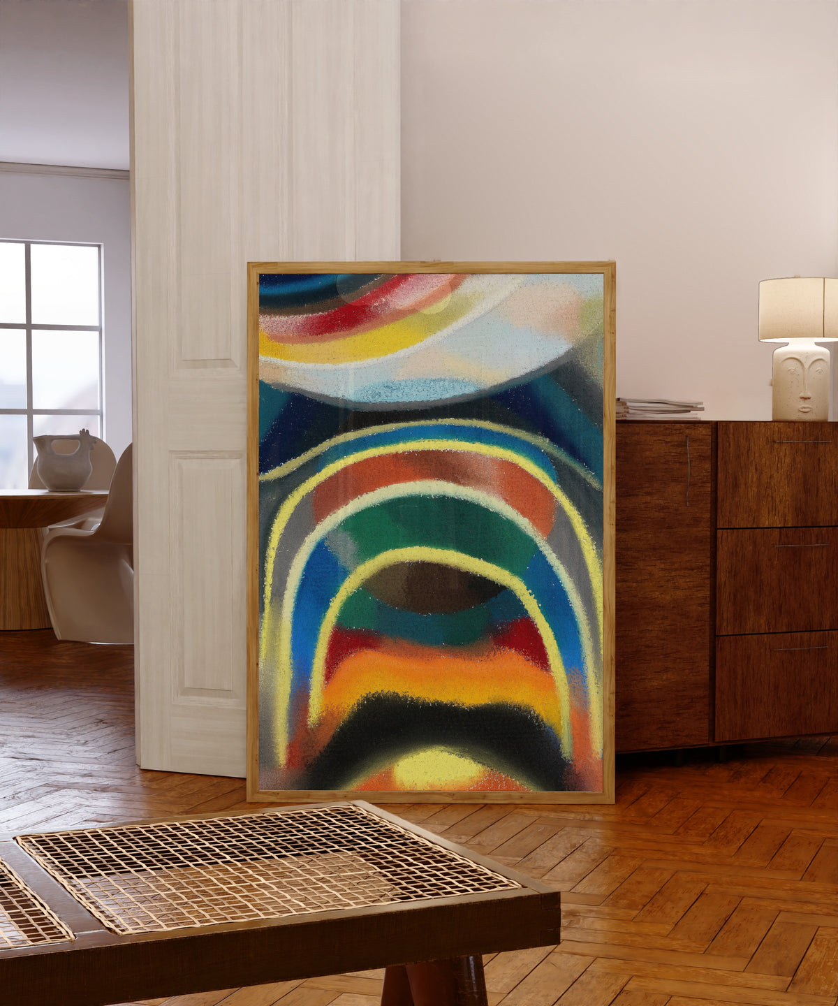 Framed art print of Lichtkreise (Kosmischer Regenbogen) (1922) by Otto Freundlich, in a light wood frame leaning in a warm room with a parquet floor