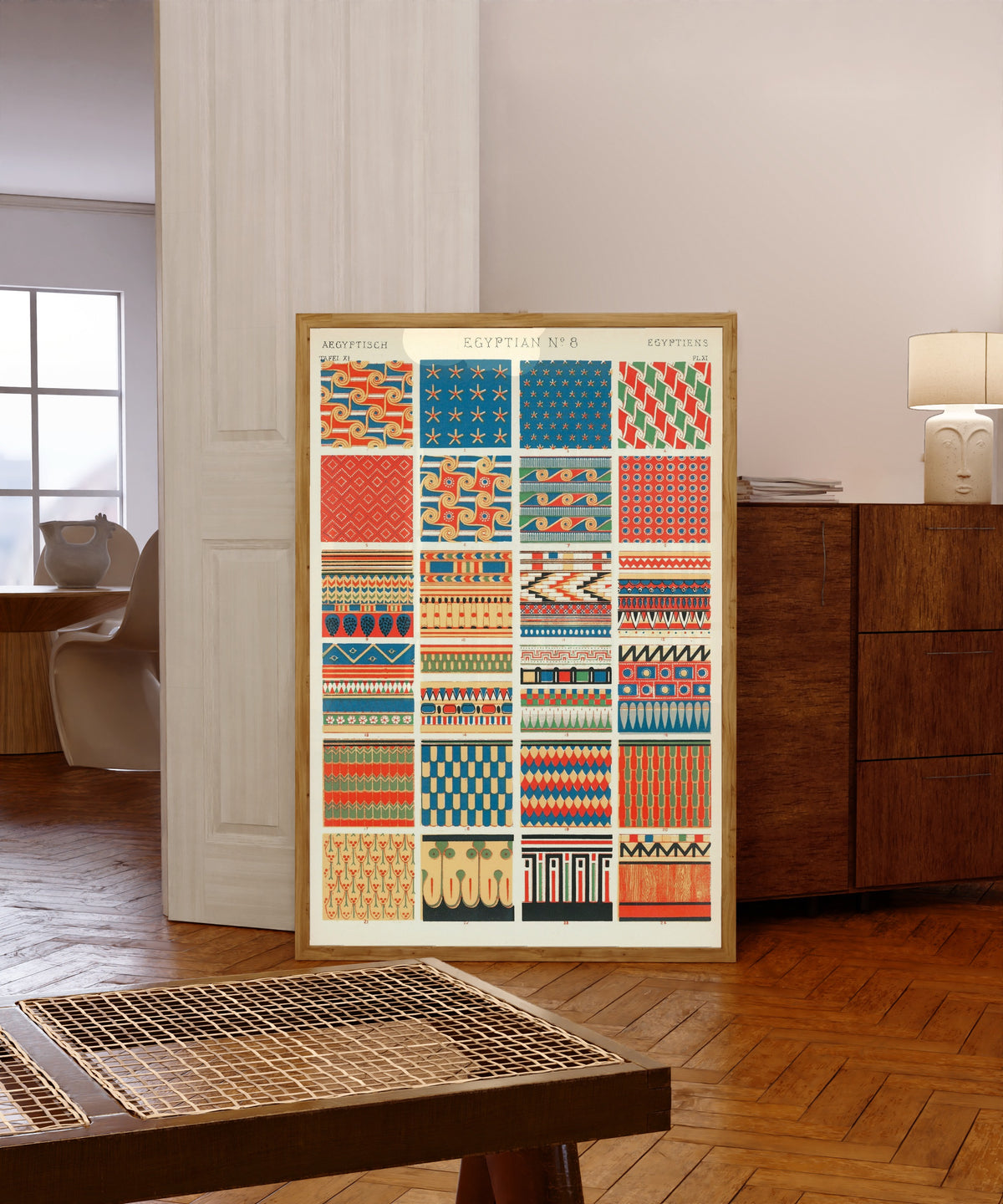 Framed art print of Egyptian by Owen Jones, in a light wood frame leaning in a warm room with a parquet floor