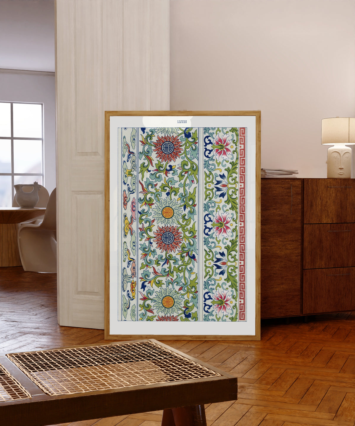 Framed art print of Examples of Chinese Ornament, Plate 73 by Owen Jones, in a light wood frame leaning in a warm room with a parquet floor