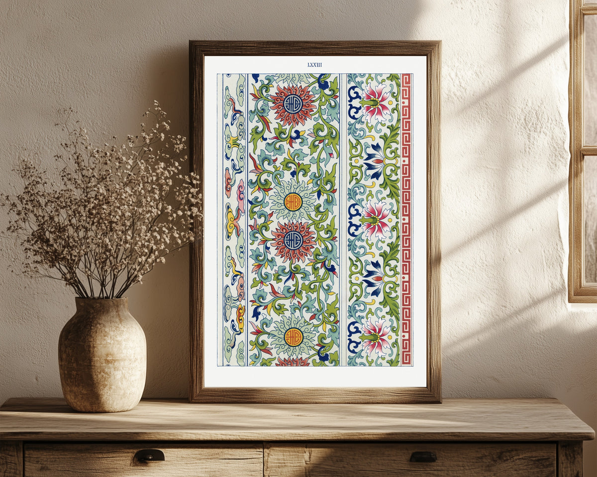 Framed art print of Examples of Chinese Ornament, Plate 73 by Owen Jones, in a dark wood frame leaning on a rustic console beside dried flowers