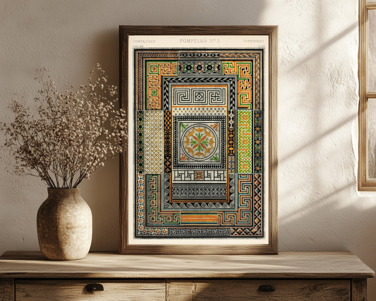 Framed art print of Pompeian by Owen Jones, in a dark wood frame leaning on a rustic console beside dried flowers