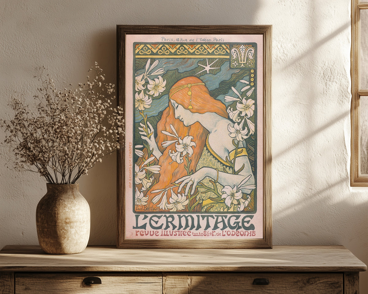 Framed art print of L'Ermitage by Paul Berthon, in a dark wood frame leaning on a rustic console beside dried flowers