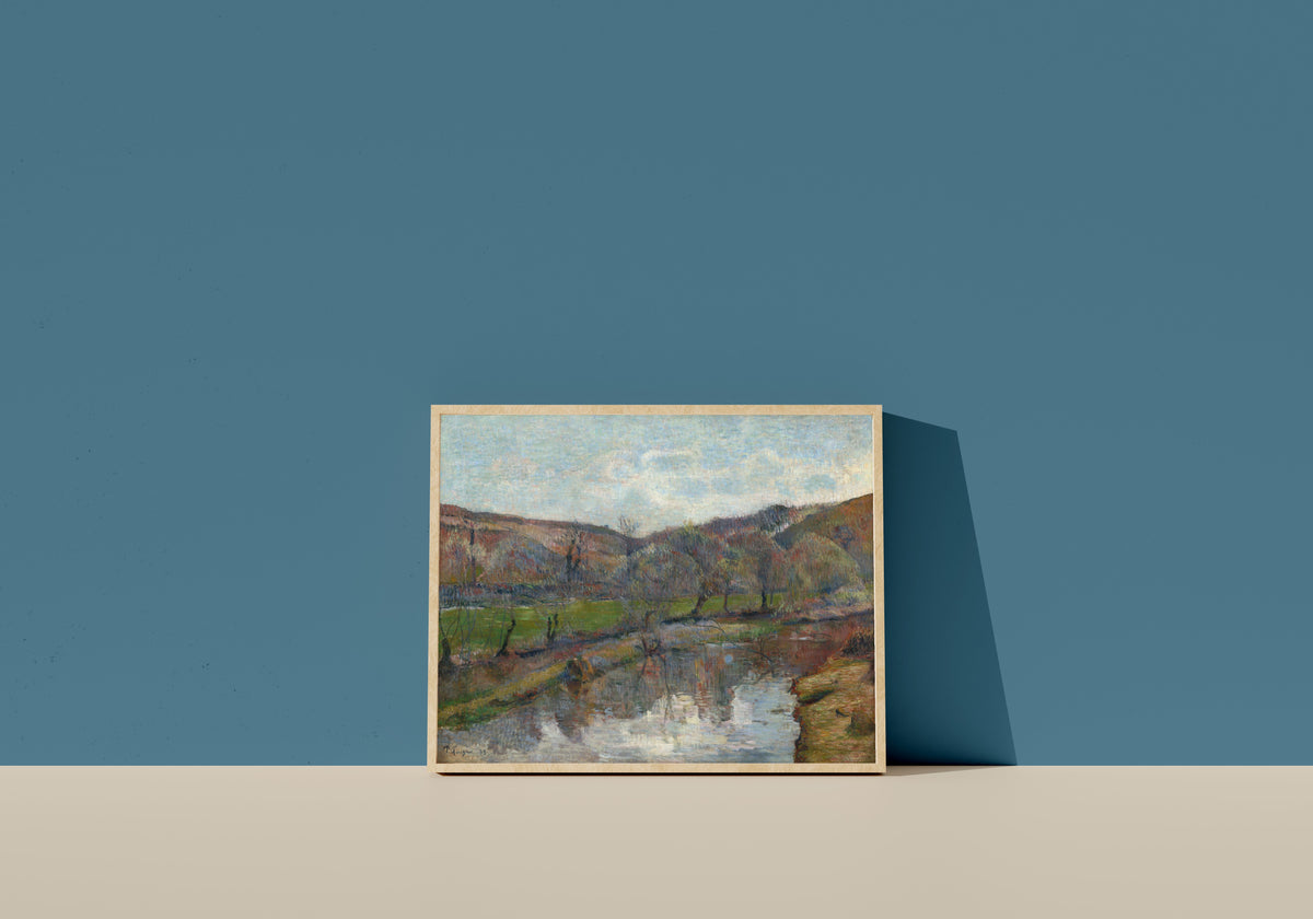 Framed art print of Brittany Landscape by Paul Gauguin, in a light wood frame leaning on a blue wall