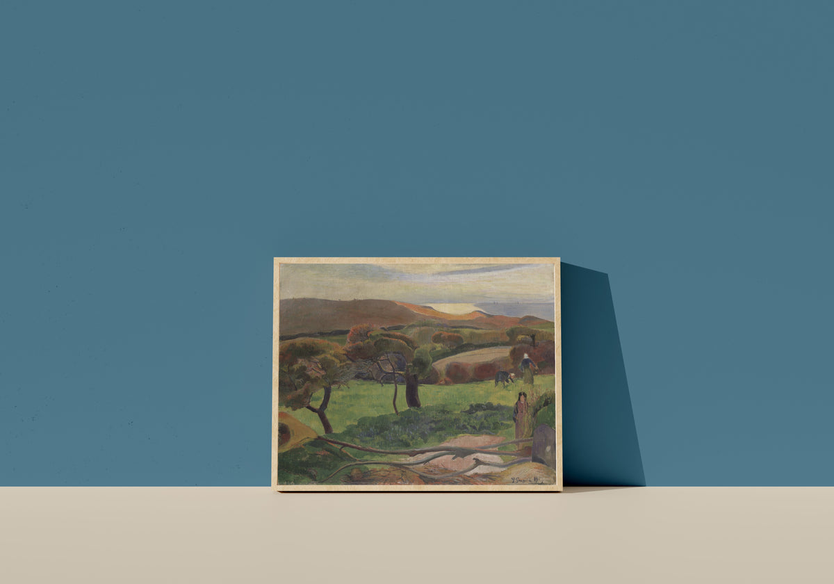 Framed art print of Landscape from Brittany (Fields by the Sea) by Paul Gauguin, in a light wood frame leaning on a blue wall