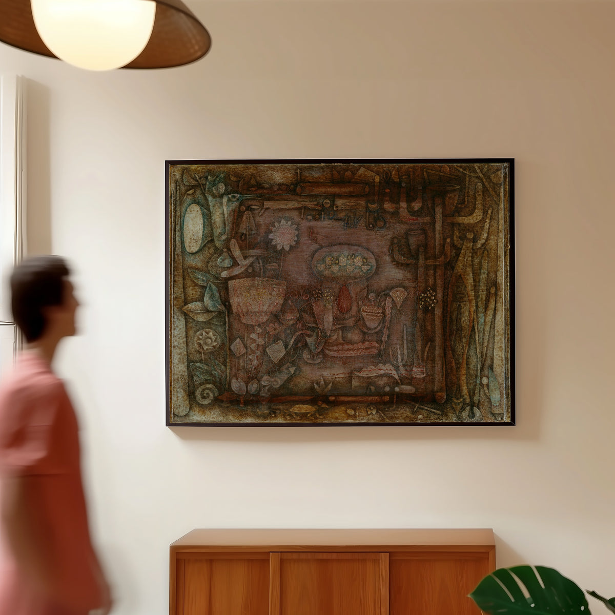 Framed art print of Botanical Theater by Paul Klee, in a slim black frame on a warm wall in a sunlit room