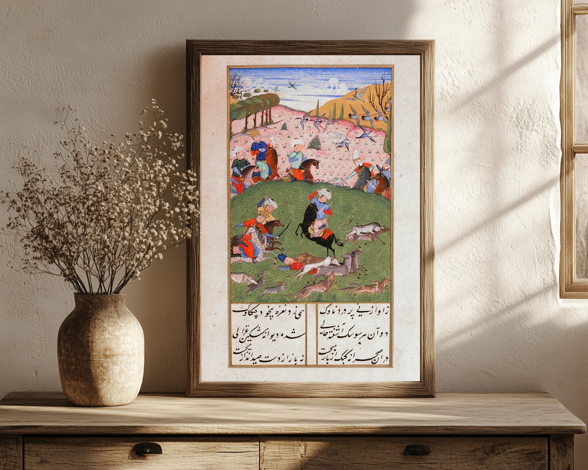 Framed art print of Khusrau and Shirin: Khusrau Hunting with His Companions by Suzi, in a dark wood frame leaning on a rustic console beside dried flowers