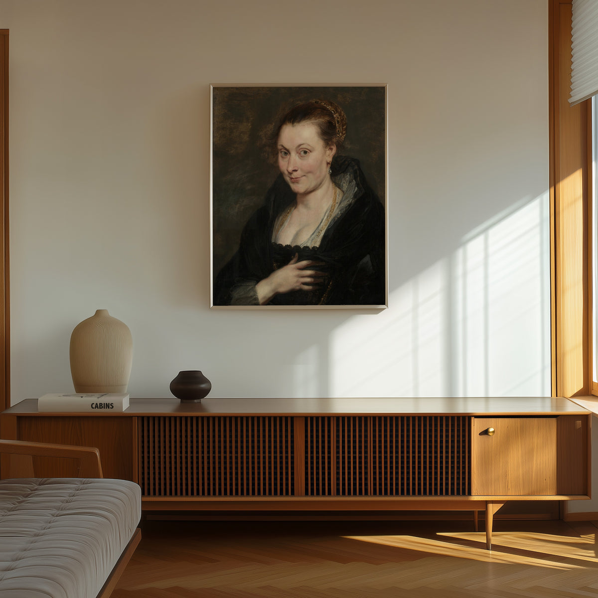 Framed art print of Portrait of Isabella Brant by Peter Paul Rubens, in a thin light frame on a sunlit wall above a wooden sideboard